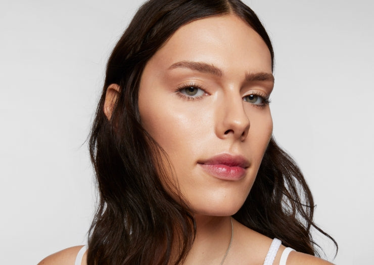 Model wears a full face of Milk Makeup Products against a white background