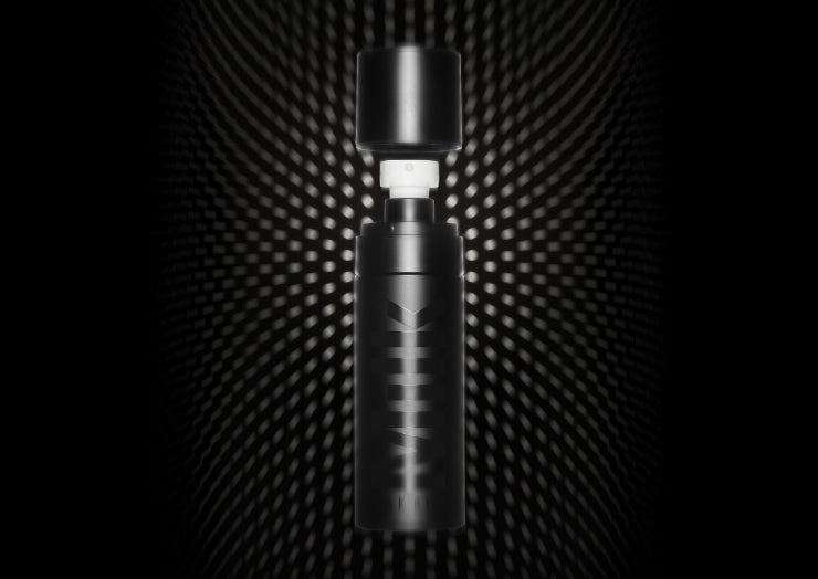 Bottle of Milk Makeup Pore Eclipse Matte Setting Spray against a black background with dots.